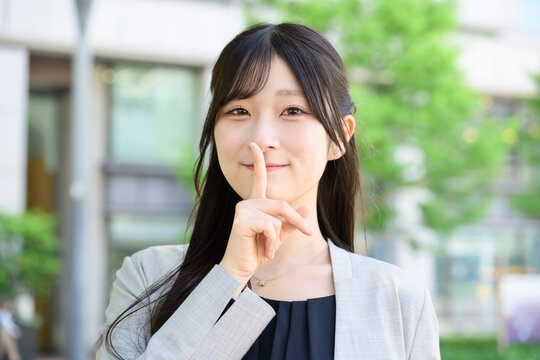 秘密のジェスチャーをする日本人女性