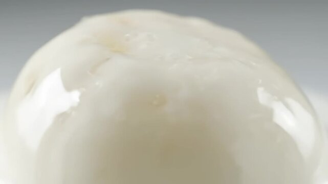 Extreme close-up of fresh italian mozzarella cheese showcasing its glossy, white, creamy texture and detail, ideal for gourmet food and recipe backgrounds.