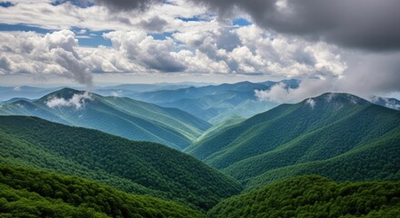 Fototapeta premium Scenic green mountain range with clouds in summer sunlight