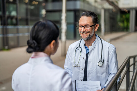 Medical professionals communicating outdoors discussing patient care