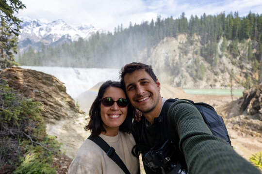 Happy couple taking a selfie by Wapta Falls in Yoho National Park