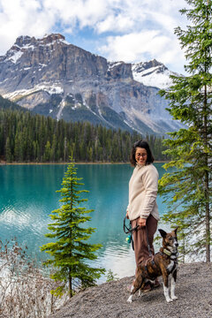 Woman and dog enjoying view of Emerald Lake, Yoho National Park