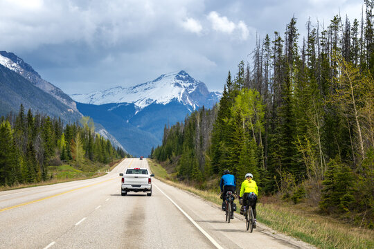 Two people cycling on a scenic mountain highway