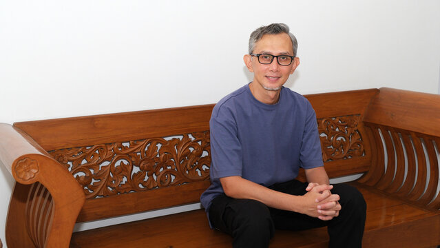 Man sitting and smiling on wooden bench