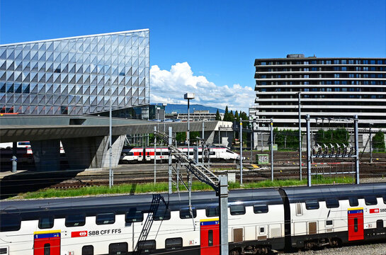 Geneva, Switzerland, Europe - 05.2026 : Stadler KISS and fast Stadler SMILE Swiss - Electric multiple unit trains, JTI headquarters of Japan Tobacco International, Picciotto students house at right