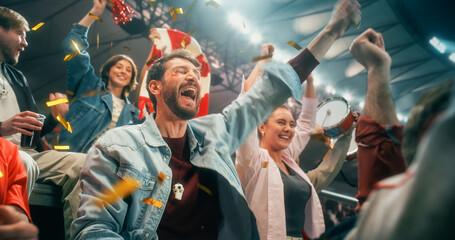 Obraz premium Energetic Portrait of Diverse Male and Female Soccer Football Fans in Championship Stadium, Arms Lifted for Happy Cheer, Smiling and Excited as Gold Confetti Flies During World Cup League Match.