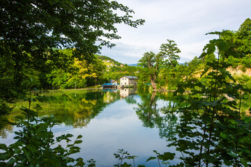 Obraz premium Scenic view of Pliva lake and historical hydro power plant station in Jajce, Bosnia and Herzegovina