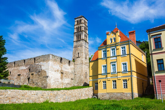 Historical St Luke bell tower and medieval church ruins next to a colorful vintage building in Jajce, Bosnia and Herzegovina