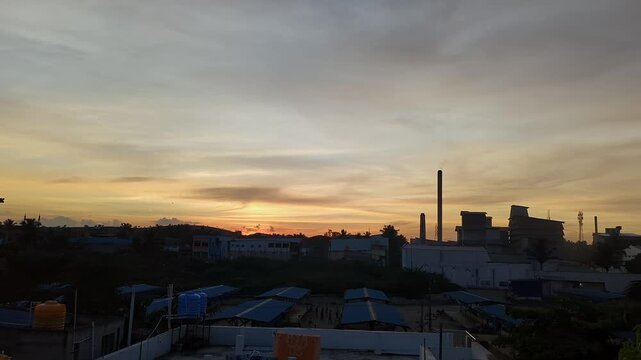 View of urban sunset with silhouetted buildings against evening sky and fading daylight horizon