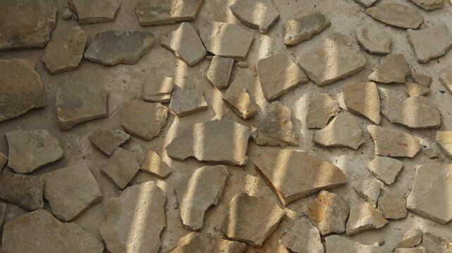 Natural flagstone pavement background with abstract shadows. Top view of irregular stone pattern tiles on outdoor patio floor. Architecture, design and construction material concept.