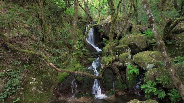 Santo Estevo do Ermo Waterfall Over Mossy Rocks In Barreiros, Galicia, Spain. Aerial Forward Shot
