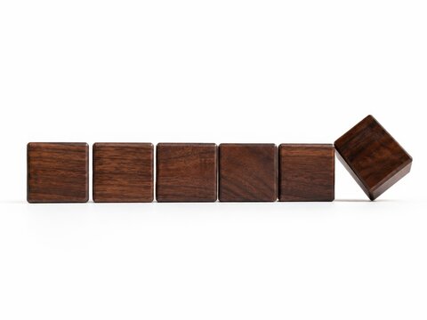 Row of premium dark walnut square wooden blank blocks aligned horizontally the final cube tilted upward on one sharp edge as if about to reveal a new blank face value change and strategic decision