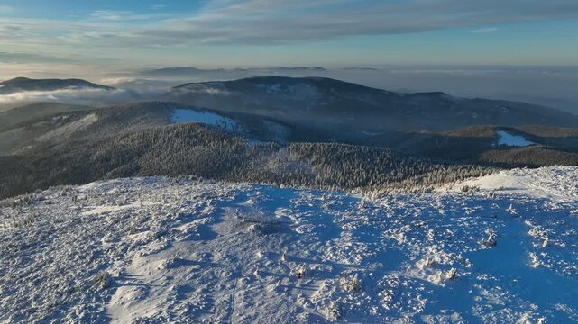 Drone rising flight over golden hour Pilsko peak revealing Beskid Slaski and Zywiecki ranges