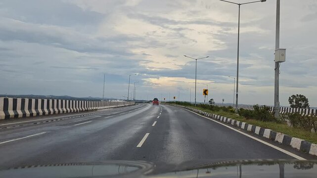 Moving shot of red car overtaking on highway capturing smooth motion and scenic road journey