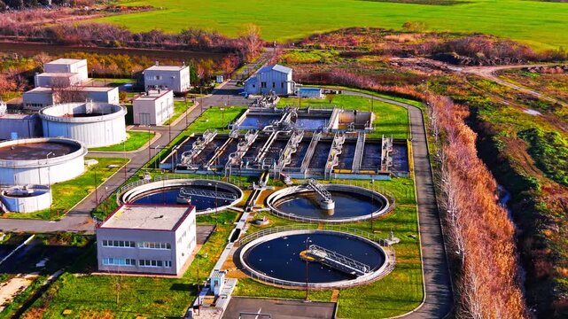 Angled drone shot of civil engineering structures, round primary clarifiers, and administrative office buildings. Water treatment plant with circular sedimentation tanks, Pomorie.