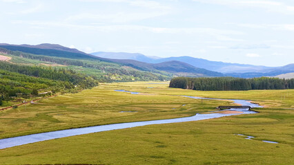 Naklejka premium Aerial View of a Winding River Through a Scottish Highland Valley