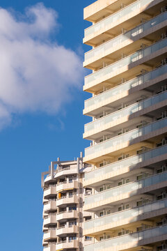 Stacked highrise balconies and apartments face blue sky in Benidorm, Spain, where tourism facade and coast light sharpen the vertical scene