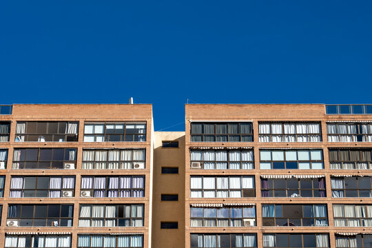 Clean apartment facade and windows face blue sky in Benidorm, Spain, giving residential tourism architecture a crisp coastal block profile