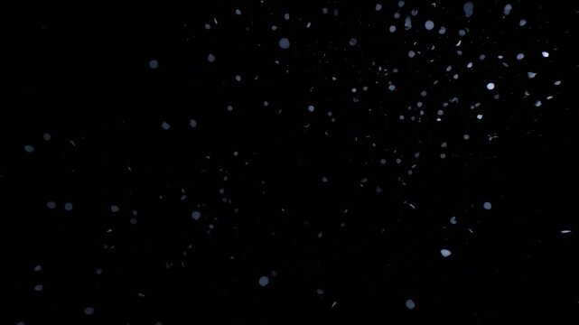 Blue particle explosion motion video featuring glowing floating digital fragments scattering against a deep dark black background visual effect