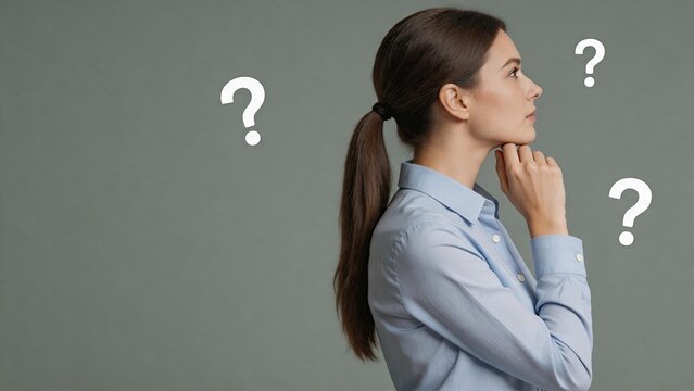 Side profile portrait of thoughtful woman looking away with question marks floating around head, representing confusion, doubt, decision making process or seeking answers to