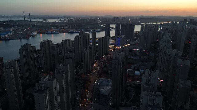 Cinematic Sunset Over Dalian Skyline in North China, Golden City Lights and Coastal Urban View