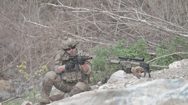 Soldier aims a rifle during training in a natural environment in the morning light