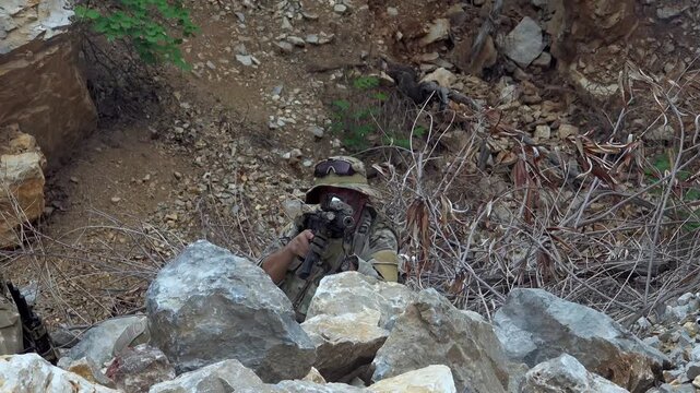 Soldiers take position in rocky terrain during training operation