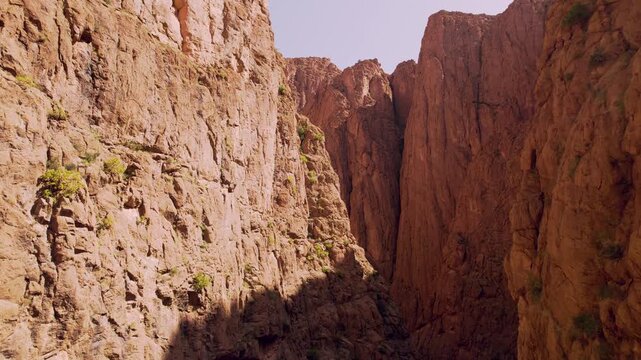 Todra Gorge near Tinghir in Draa-Tafilalet, Morocco, carved through limestone and sandstone cliffs between the High Atlas and Jbel Saghro ranges, low forward flyover reveal shot.
