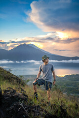 Fototapeta premium Photographer Standing on Mount Batur Ridge at Sunrise Bali