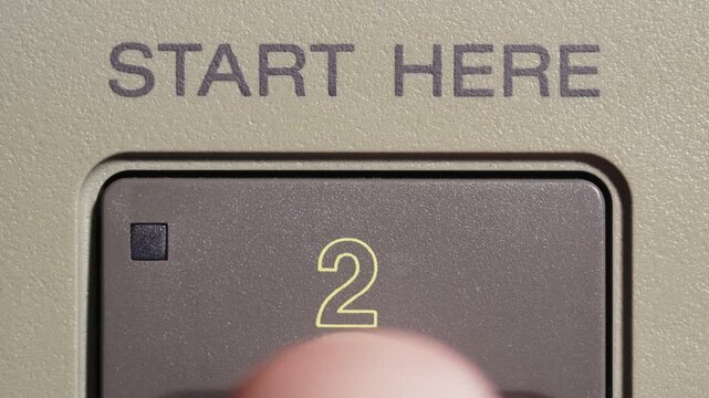 Finger presses start here button marked 2 on beige vintage editing remote controller