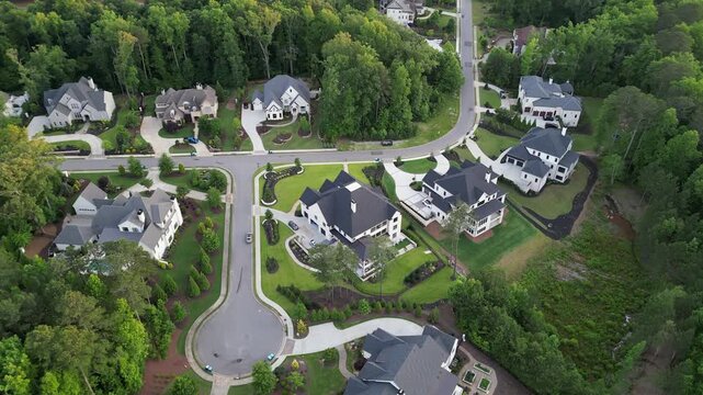 Aerial circles low over mansions in affluent suburban neighborhood