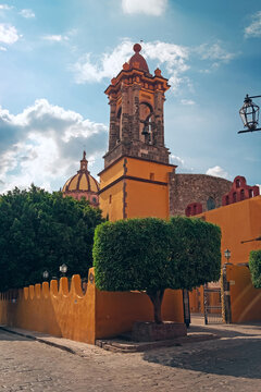 Facade of the Church of the Immaculate Conception - a yellow church with bell-towers and dome in San Miguel de Allende, Guanajuato, Mexico, North America