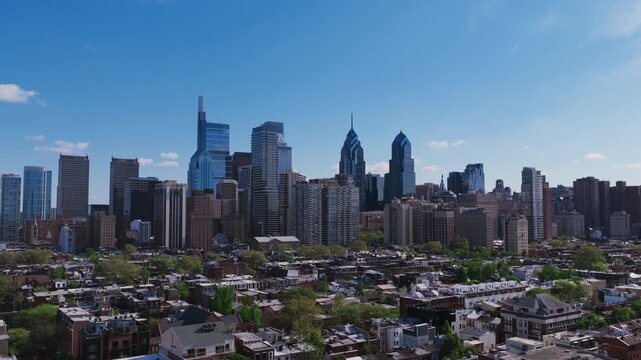 Wide aerial drone view of Philadelphia's full downtown skyline with Comcast towers, One and Two Liberty Place, and residential neighborhoods in the foreground.