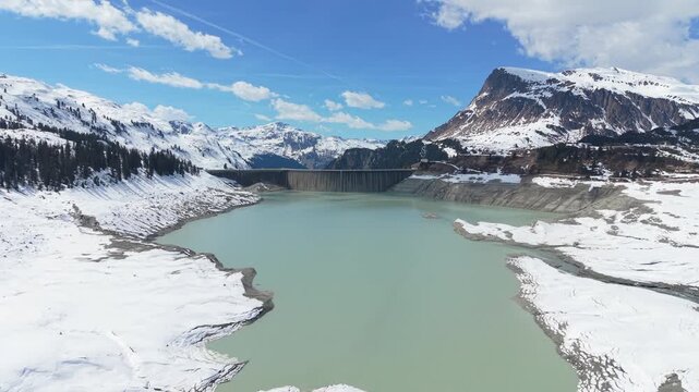 Hydroelectric Dam Reservoir Lake in Snowy Mountain Landscape AERIAL