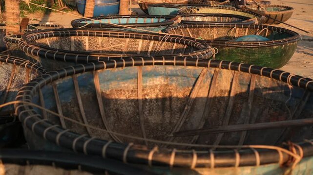 Sunlight Highlights Ties On Quiet Boats. Focus On Intimate Craft With Coracle Textures On Sand. Close Up Of Coracle Textures On Da Nang Sand With Worn Paint And Woven Rim