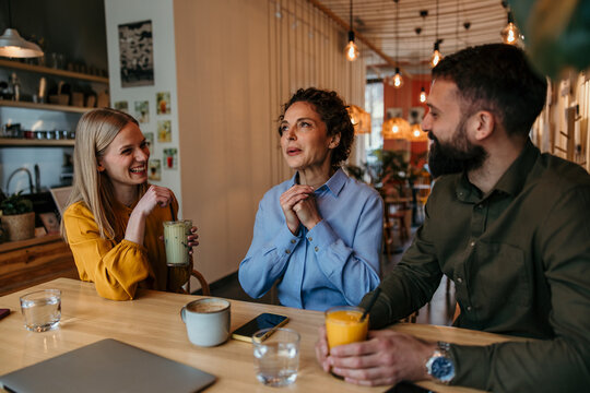 Diverse friends enjoying coffee house discussion and socializing