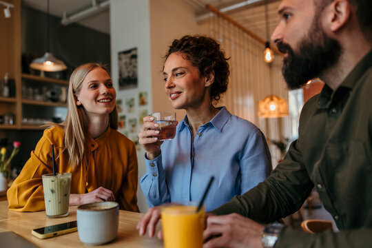 Friends enjoying drinks and conversation in cafe
