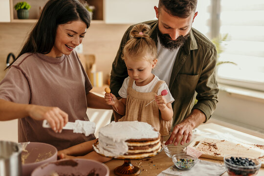Family baking cake together in kitchen at home