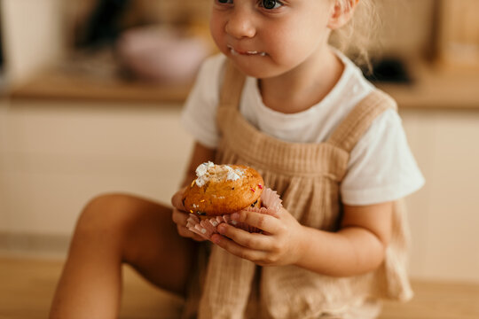 Toddler girl enjoying sweet muffin snack