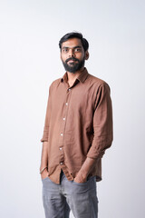 Fototapeta premium Young indian man standing confidently on white background