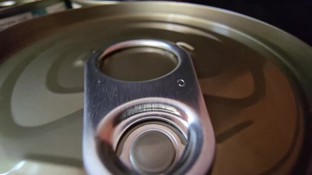 Macro shot of a metal tin can lid with an easy-open ring pull, highlighting food packaging and emergency storage.