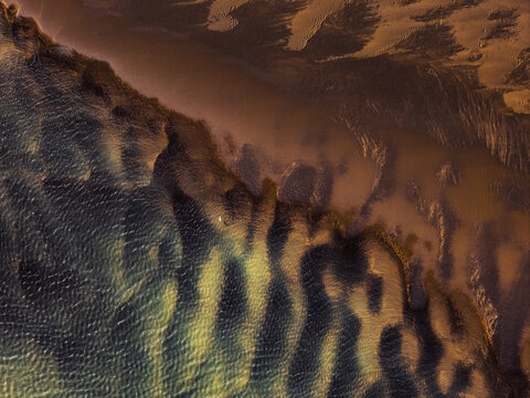 Aerial view of the abstract patterns of water ripples and sediment on the black sand beach near Vik, Myrdalshreppur, Iceland. I call it Tiger Stripes!