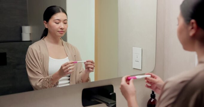 Pregnancy, test and mirror with asian woman in bathroom for ovulation, hormone level or waiting. Reproduction kit, fertility screening and hcg check with person in home for nervous for results