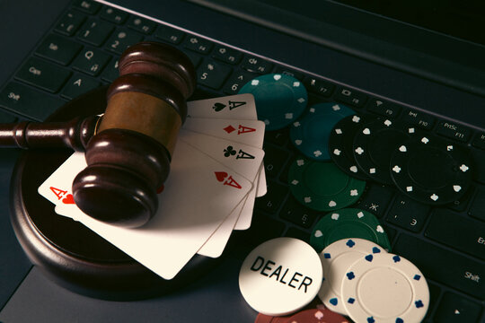 Online casino concept. Gavel, chips and cards on laptop keyboard