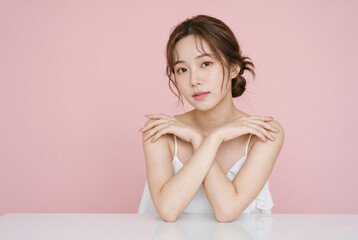 Naklejka premium ピンク背景で撮影されたリラックスした女性ポートレート写真