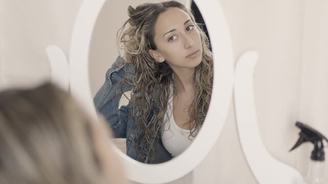 Beautiful woman checking her hair in the mirror