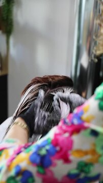 Gros plan zoom application et shampooing de couleur coloration au salon de coiffure chez la coiffeuse coiffeur