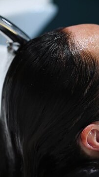 Gros plan zoom application et shampooing de couleur coloration au salon de coiffure chez la coiffeuse coiffeur