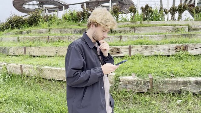Lifestyle portrait of young man using a smartphone outdoors