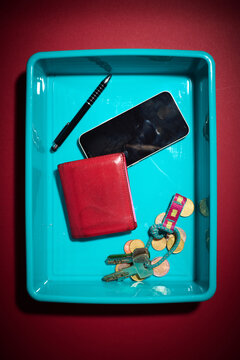 Personal belongings placed in the plastic tray at a security checkpoint.
